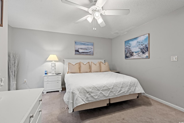 bedroom featuring ceiling fan, a textured ceiling, and light colored carpet