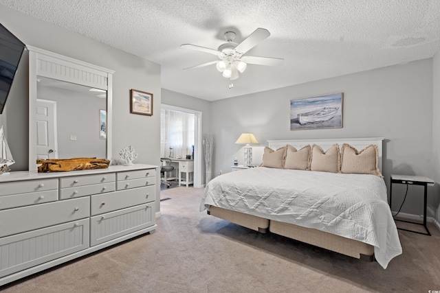 carpeted bedroom with a textured ceiling and ceiling fan