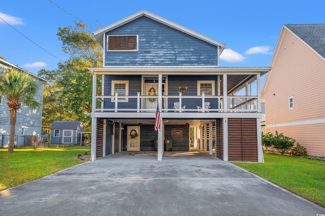 view of front facade with a front lawn, covered porch, and a carport