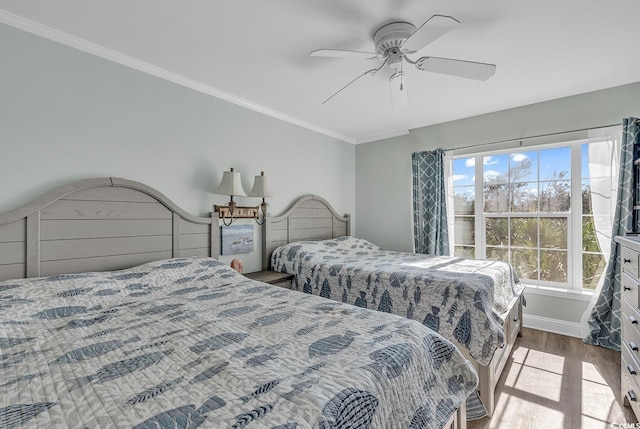 bedroom featuring wood finished floors, ornamental molding, ceiling fan, and baseboards