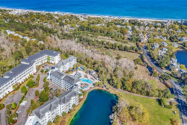 birds eye view of property featuring a water view and a beach view