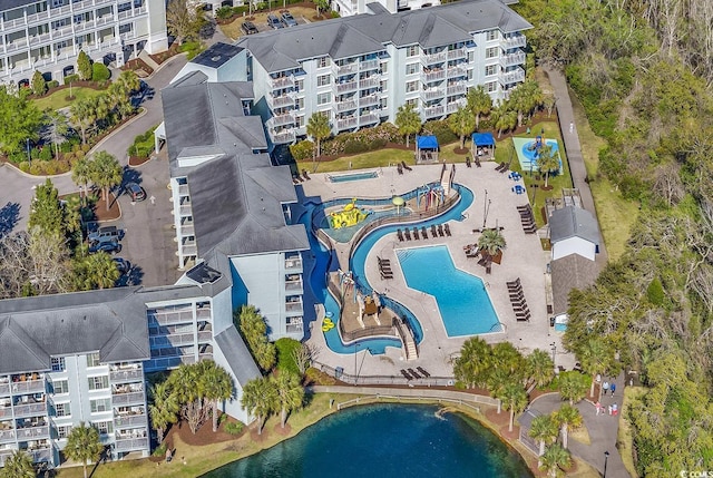 drone / aerial view of apartment complex, a pool, and a large body of water