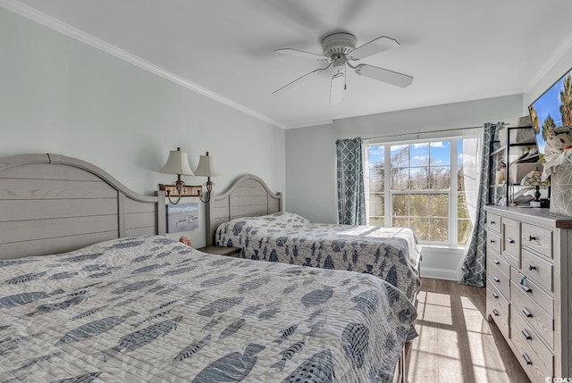 bedroom with ceiling fan, crown molding, and light wood-type flooring