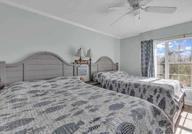 bedroom with ornamental molding, ceiling fan, and wood finished floors