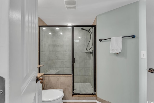 bathroom with toilet and an enclosed shower