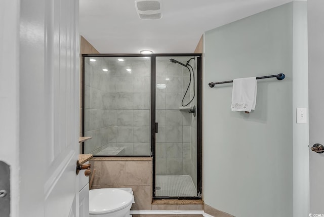bathroom with toilet and a shower stall