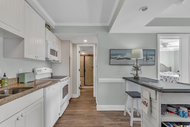 kitchen with crown molding, white cabinetry, hardwood / wood-style floors, and white appliances