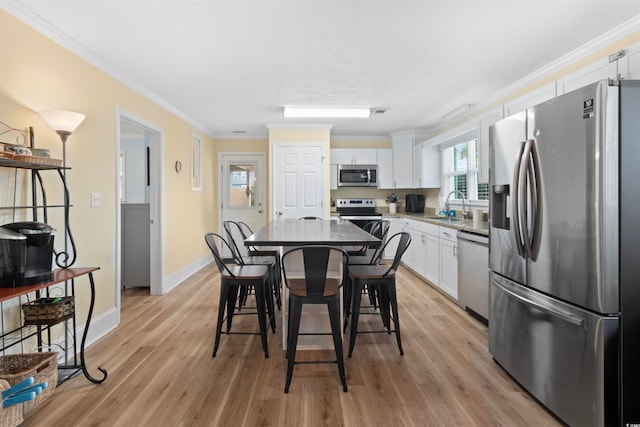 kitchen with white cabinetry, sink, light hardwood / wood-style flooring, and appliances with stainless steel finishes