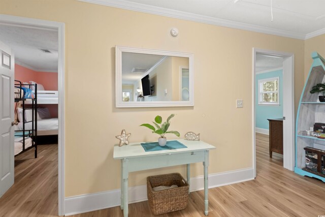 hallway featuring light hardwood / wood-style flooring and crown molding