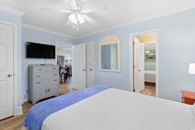 bedroom featuring ornamental molding, connected bathroom, stainless steel refrigerator, ceiling fan, and light hardwood / wood-style flooring