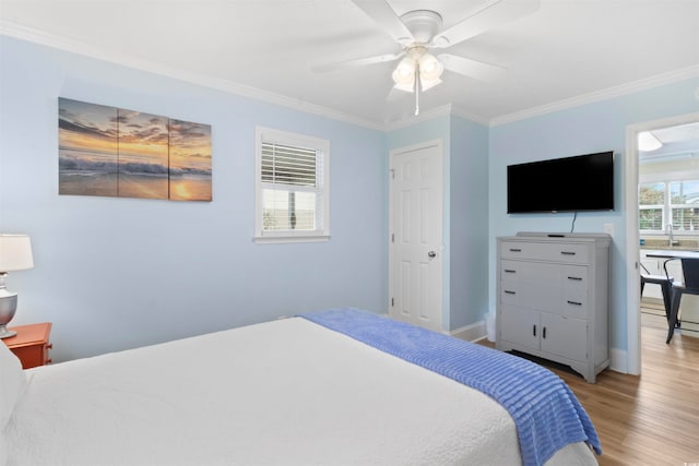 bedroom with light hardwood / wood-style floors, ceiling fan, and crown molding