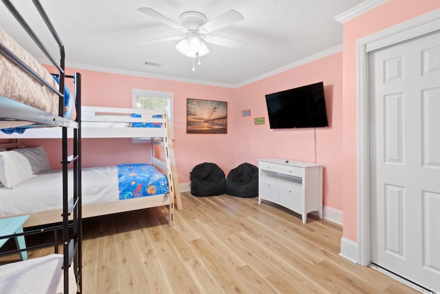 bedroom with light hardwood / wood-style floors, ceiling fan, and crown molding