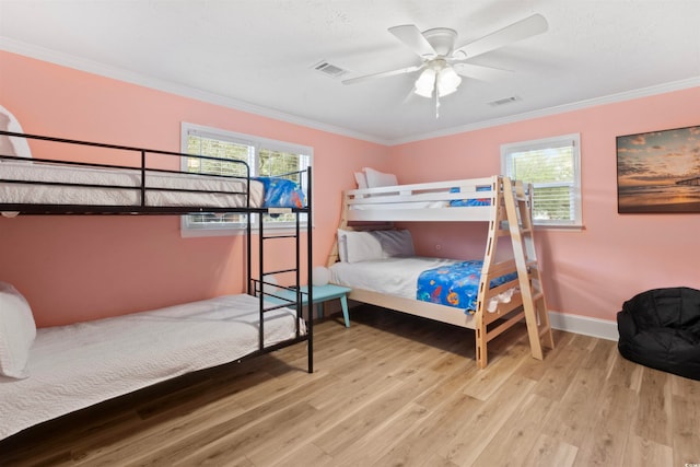 bedroom with ornamental molding, wood-type flooring, and ceiling fan