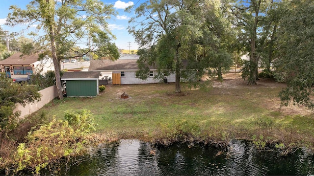 view of yard featuring a water view and a storage unit