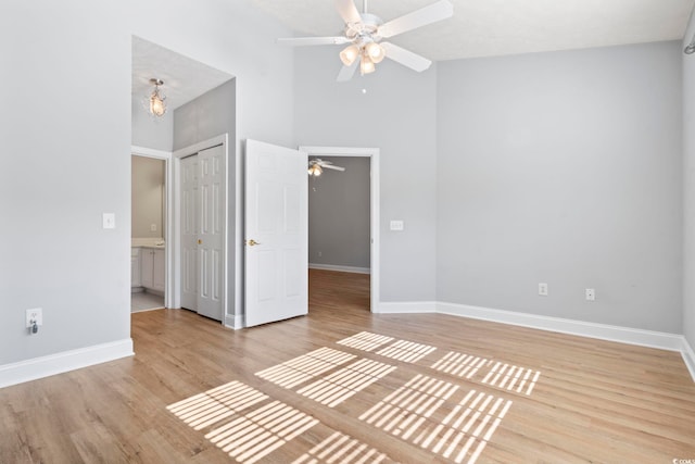 interior space featuring ceiling fan, a closet, light hardwood / wood-style flooring, and high vaulted ceiling