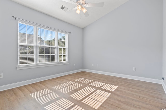 unfurnished room featuring ceiling fan, a healthy amount of sunlight, light wood-type flooring, and vaulted ceiling