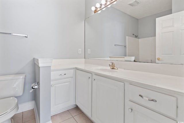 bathroom with vanity, tile patterned flooring, toilet, and a shower