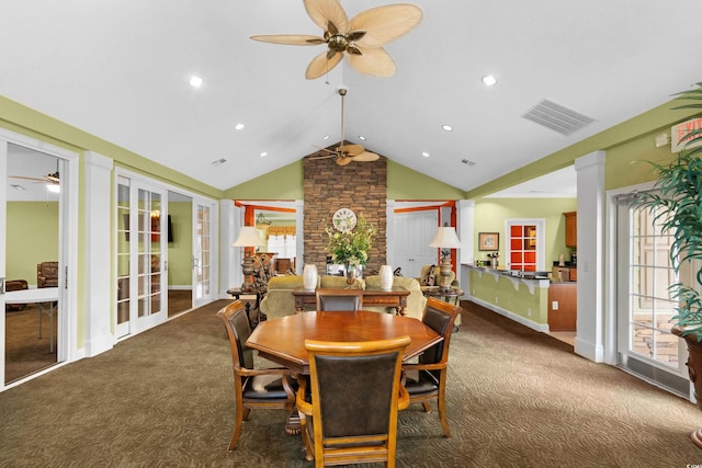 carpeted dining space featuring french doors, decorative columns, and lofted ceiling