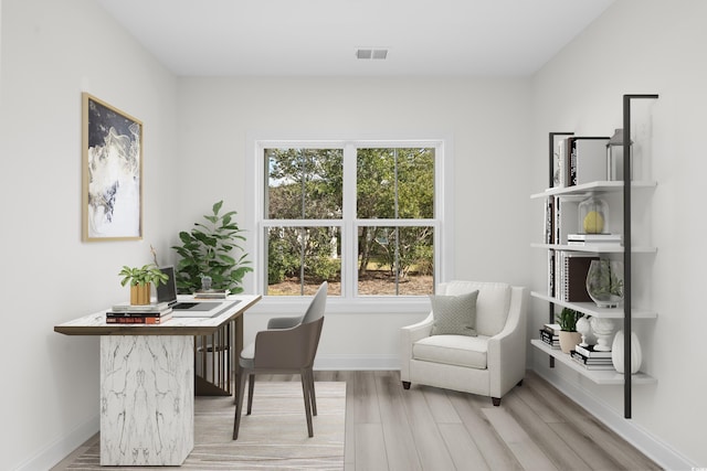 home office with a wealth of natural light and wood-type flooring