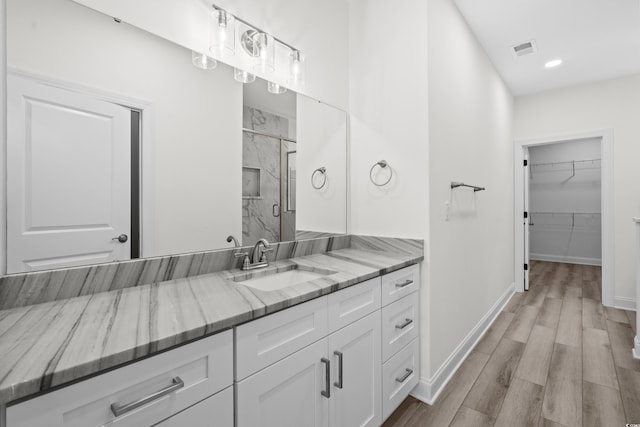 bathroom with a shower with door, vanity, and hardwood / wood-style floors