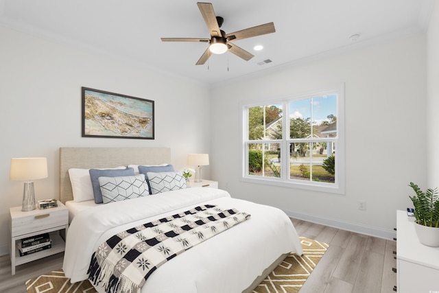 bedroom featuring ceiling fan, light hardwood / wood-style floors, and ornamental molding