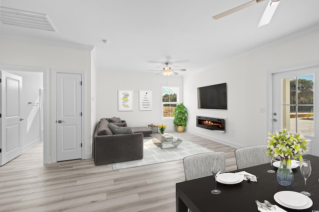 living room with ceiling fan, light hardwood / wood-style floors, and crown molding