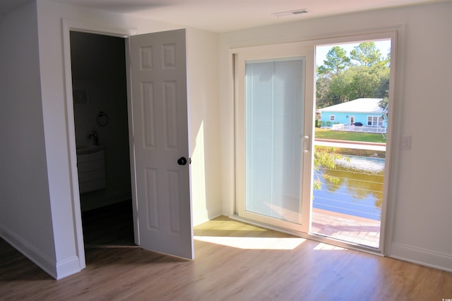 entryway with visible vents, light wood-type flooring, and baseboards