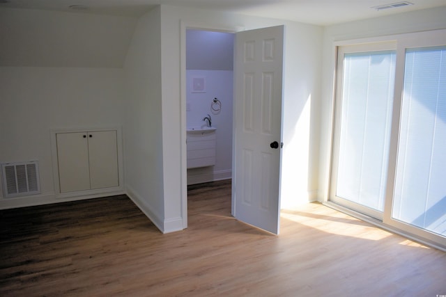 unfurnished bedroom featuring visible vents, baseboards, and wood finished floors