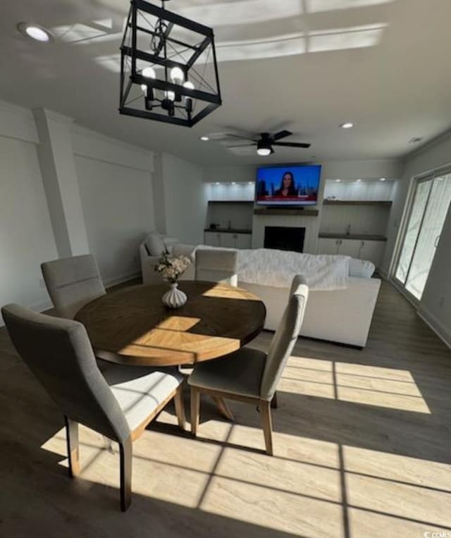 dining area with recessed lighting, a fireplace, ceiling fan, and wood finished floors