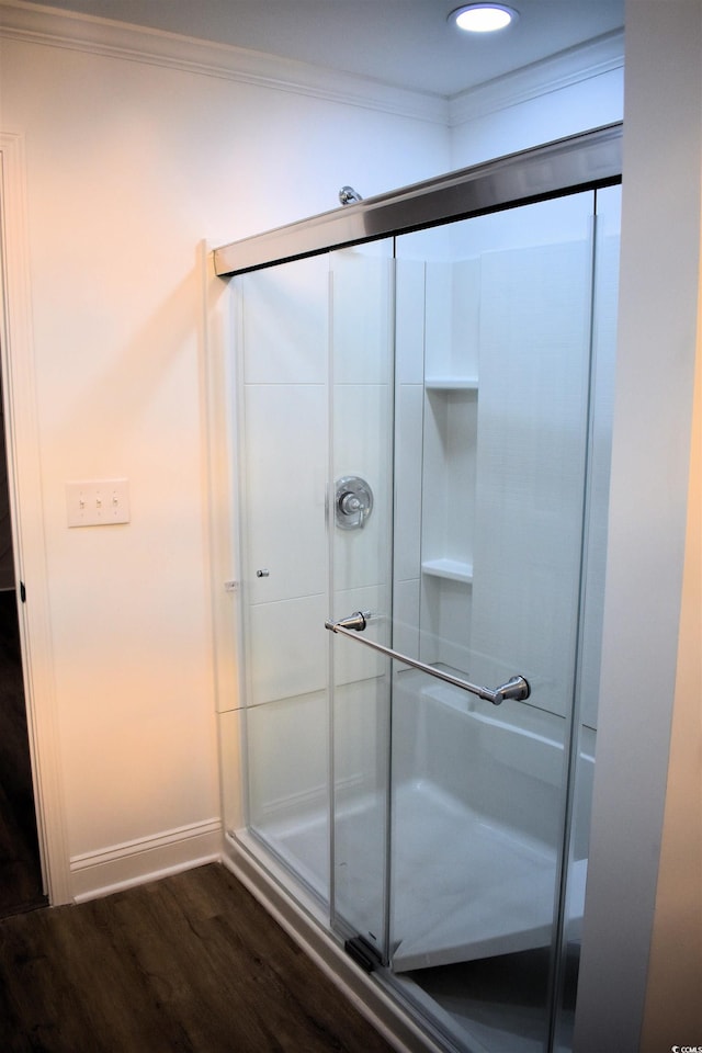 full bathroom featuring a stall shower, wood finished floors, recessed lighting, crown molding, and baseboards