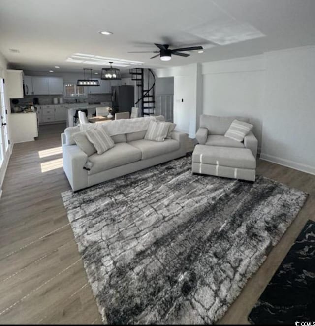 living room featuring stairway, wood finished floors, baseboards, recessed lighting, and ceiling fan