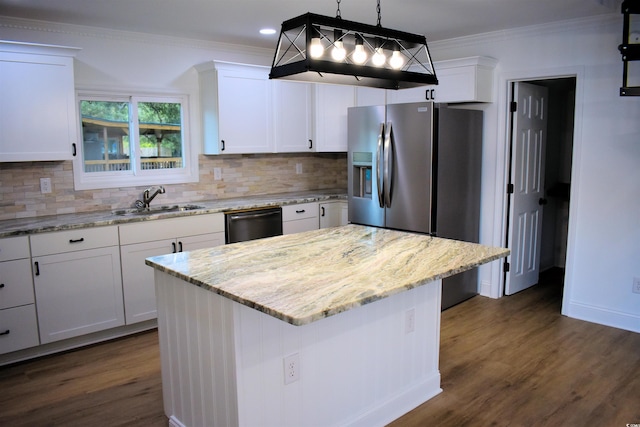 kitchen with a sink, dishwasher, ornamental molding, and white cabinetry