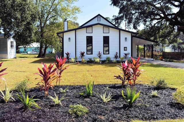 37 Geney Ln, Pawleys Island, SC 29585 - bungalow-style home featuring a chimney, a front yard, fence, concrete driveway, and an attached carport