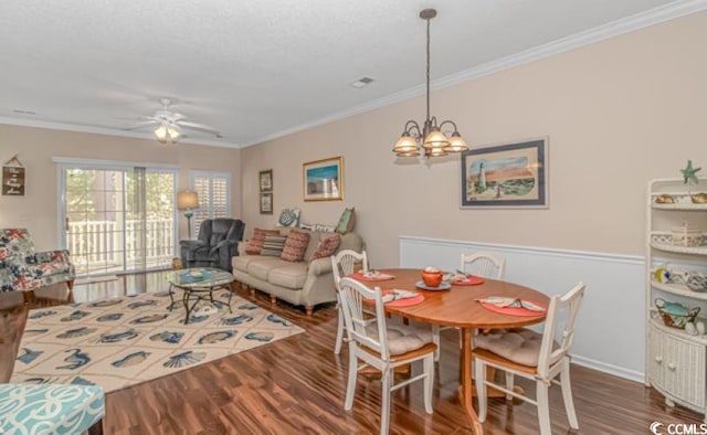 dining space featuring ornamental molding, a textured ceiling, wood-type flooring, and ceiling fan with notable chandelier