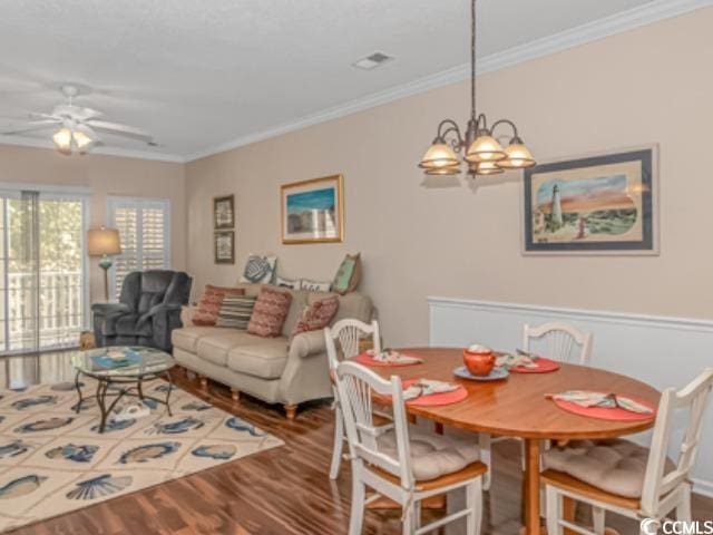 5804 Longwood Dr Unit 203, Murrells Inlet, SC 29576 - dining space featuring wood finished floors, crown molding, ceiling fan, and a chandelier