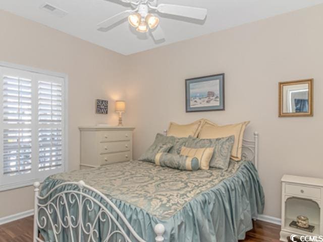 bedroom with ceiling fan, multiple windows, and dark hardwood / wood-style floors