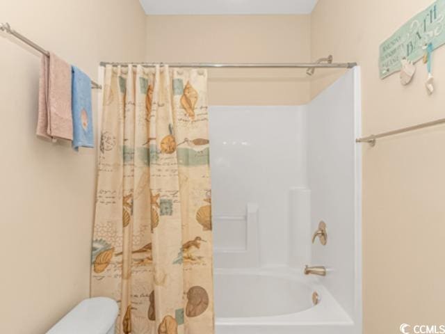 bathroom with shower / bath combo and toilet