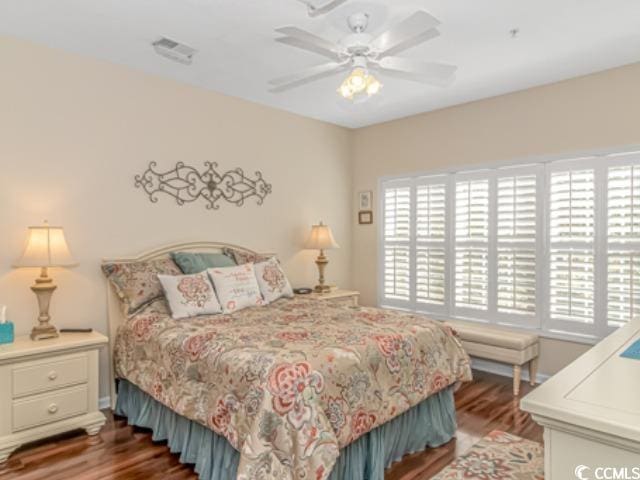 bedroom with ceiling fan, hardwood / wood-style flooring, and multiple windows