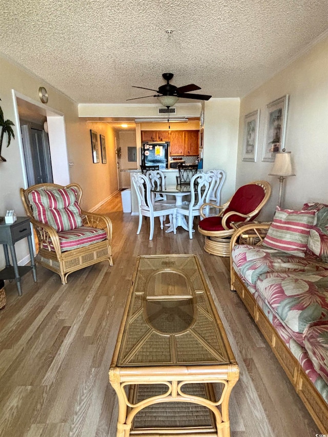 living room featuring hardwood / wood-style floors, a textured ceiling, and ceiling fan