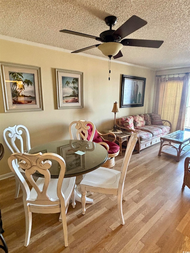 dining space with ornamental molding, a textured ceiling, light hardwood / wood-style floors, and ceiling fan