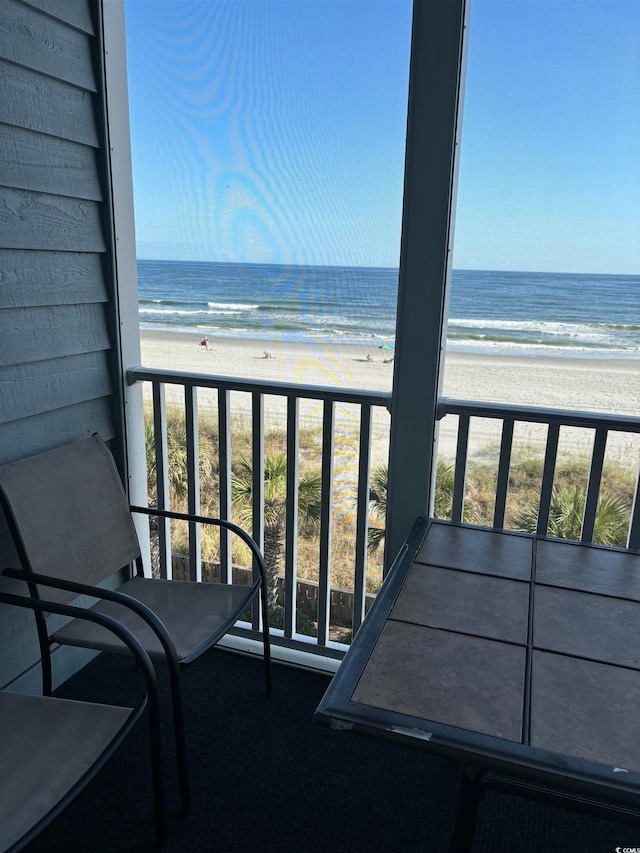 balcony with a water view and a beach view