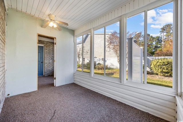 unfurnished sunroom featuring ceiling fan and a wealth of natural light