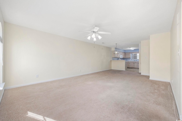 unfurnished living room with light colored carpet and ceiling fan