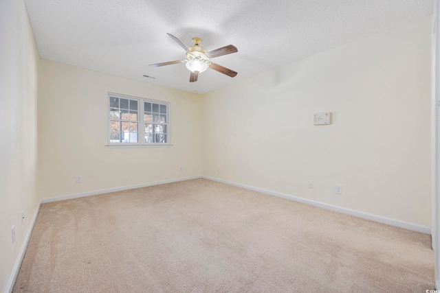 unfurnished room featuring a textured ceiling, light colored carpet, and ceiling fan