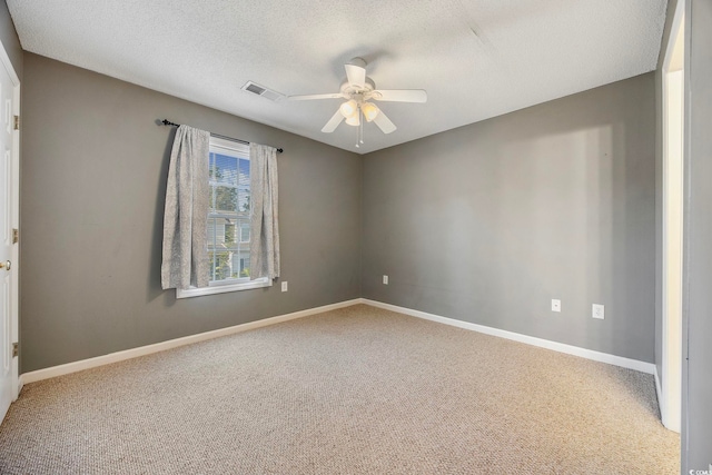 spare room with ceiling fan, carpet flooring, and a textured ceiling