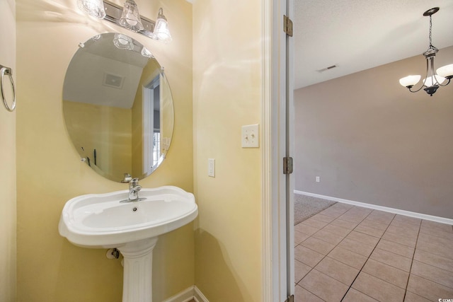 bathroom with tile patterned floors and a chandelier