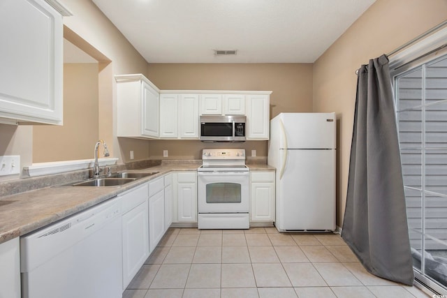 kitchen featuring sink, light tile patterned flooring, white cabinetry, a textured ceiling, and white appliances