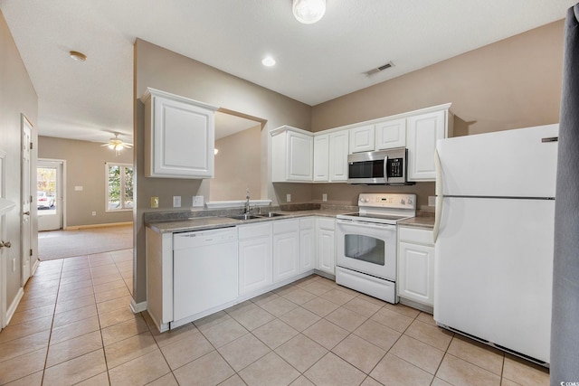 kitchen featuring white cabinetry, sink, light tile patterned floors, and white appliances