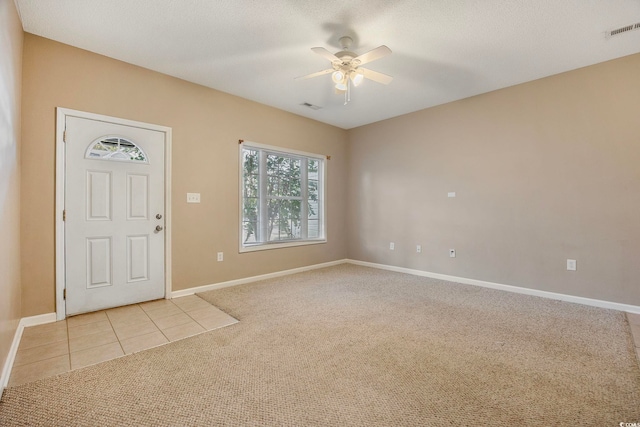 entryway featuring light carpet, a textured ceiling, and ceiling fan