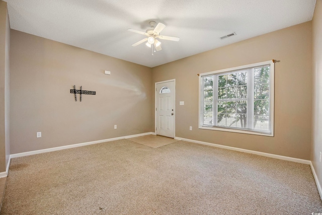 carpeted spare room featuring a textured ceiling and ceiling fan